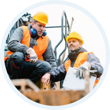 Site managers discussing plans beside construction equipment