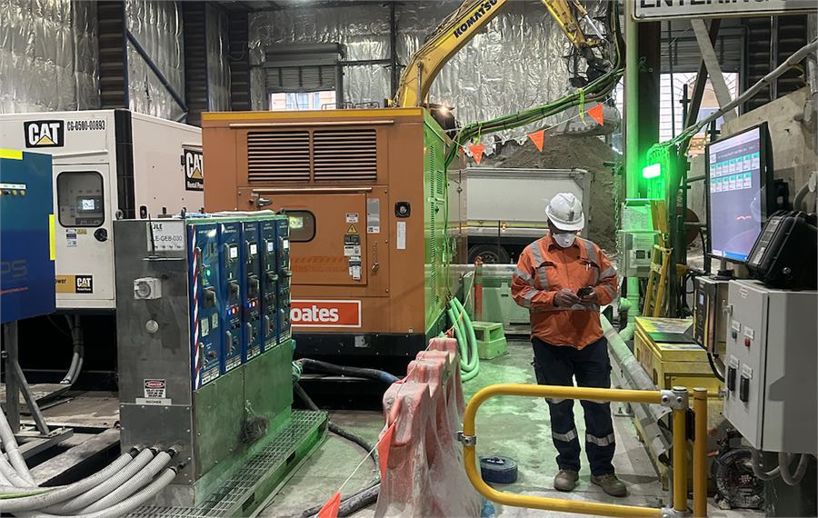 Contractor operating site equipment beside a control panel