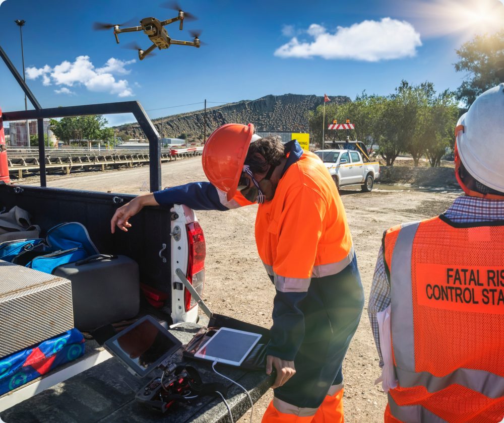 Fatal risk control station operator reviewing drone and tablet data at a vehicle tailgate